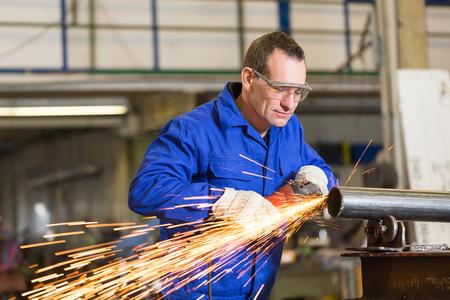 用角磨机研磨金属的钢结构建筑工人在工厂的工业金属切削刀具,滑动